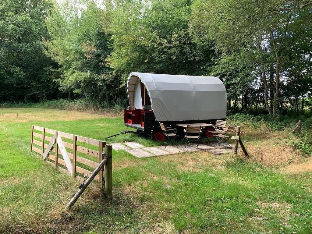 a white trailer parked in a field next to a fence at Huifkar in landelijke omgeving in Ureterp