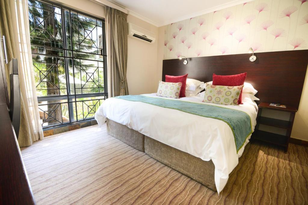 a bedroom with a large bed and a large window at Signal Hill Lodge in Cape Town