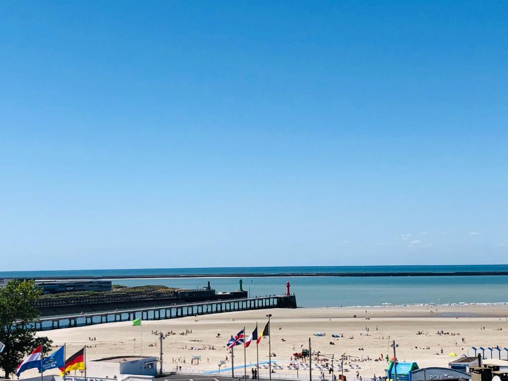 een strand met een pier en een hoop mensen bij "BELLEVUE" Magnifique appartement vue sur mer et face à Nausicàa in Boulogne-sur-Mer