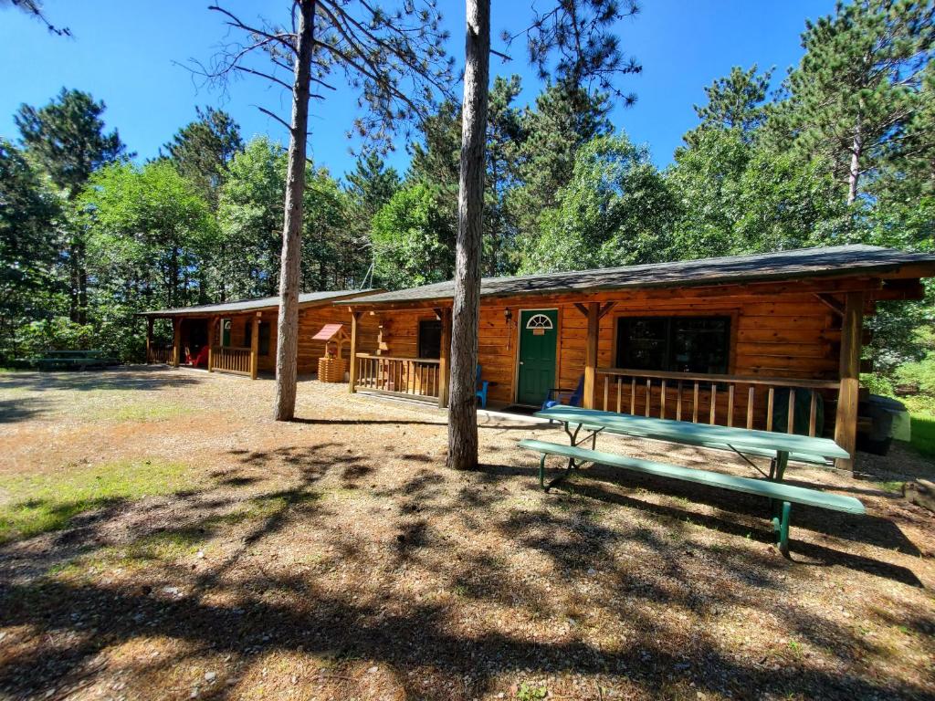 a log cabin with a bench in front of it at Crossroads motel & cabins in Oxford