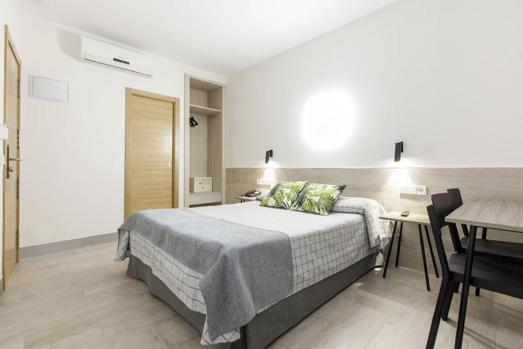 a hotel room with a bed, chair, and table at Hostal Castilla II Puerta del Sol in Madrid
