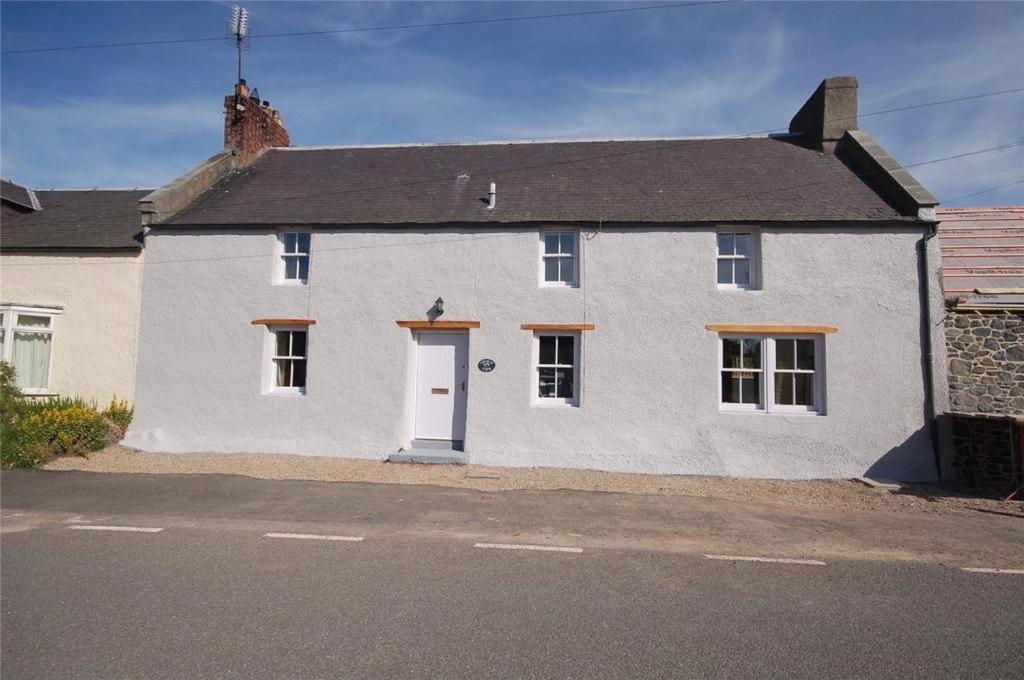 una casa blanca con una puerta blanca en una calle en Church View, en Kirk Yetholm