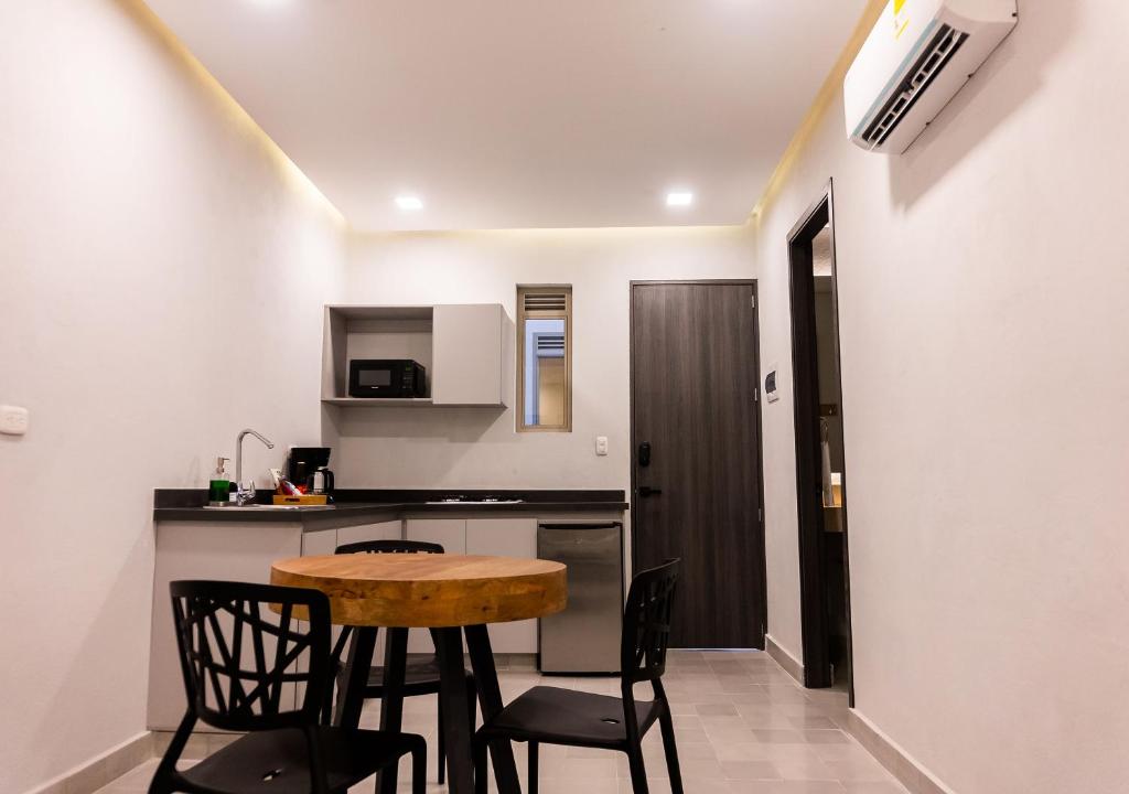 a small kitchen with a table and chairs in a room at The Garden by DOT Suites in Santa Marta