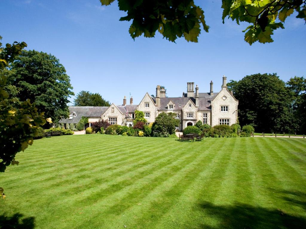 a large house with a large lawn in front of it at Langrish House in Petersfield