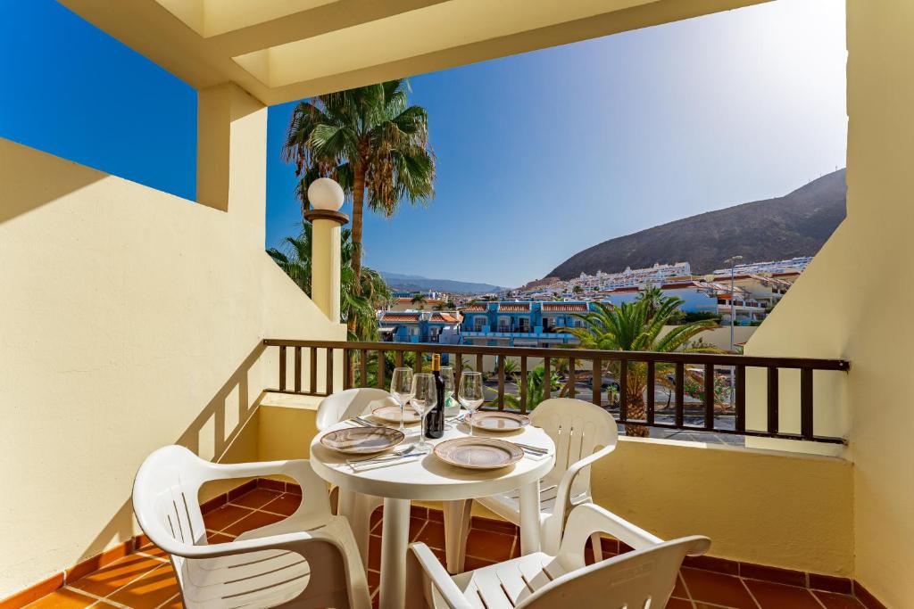 a dining room table with chairs and umbrellas at Klayman Olivina Aparthotel in Los Cristianos