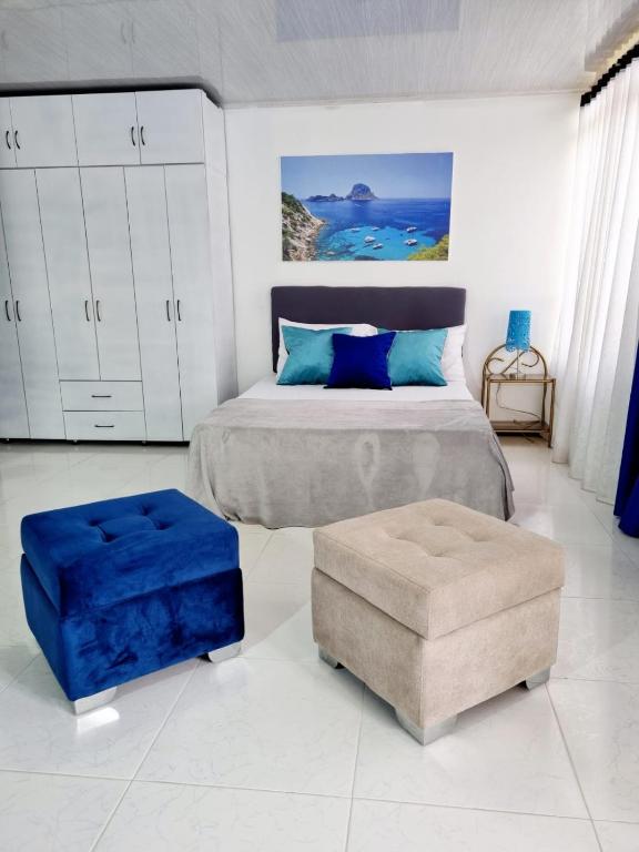 a bedroom with a bed and a ottoman at Apartaestudio IBIZA 401 Edificio Europa Ibagué in Ibagué