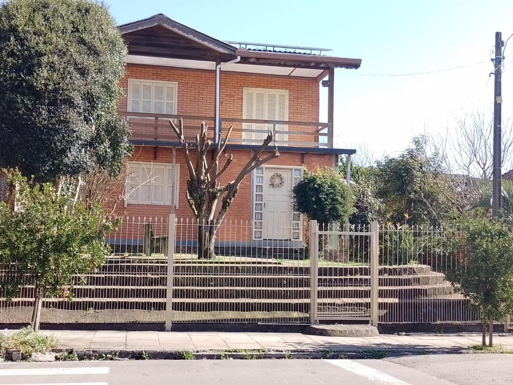 a house with a fence in front of it at Casa aconchegante em Canela in Canela