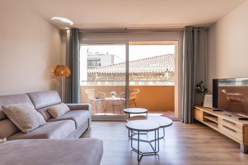 ein Wohnzimmer mit einem Sofa und einem Tisch in der Unterkunft Bravissimo Falcó, 3 bedrooms and balcony in Girona