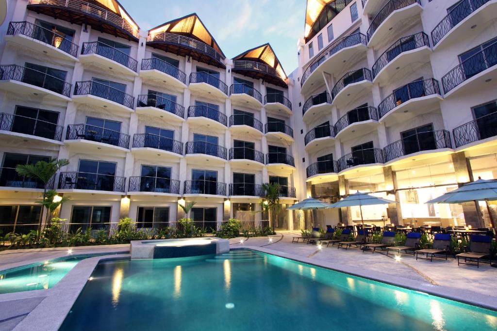 a hotel with a swimming pool in front of a building at Oceano Boutique Hotel & Gallery in Jacó