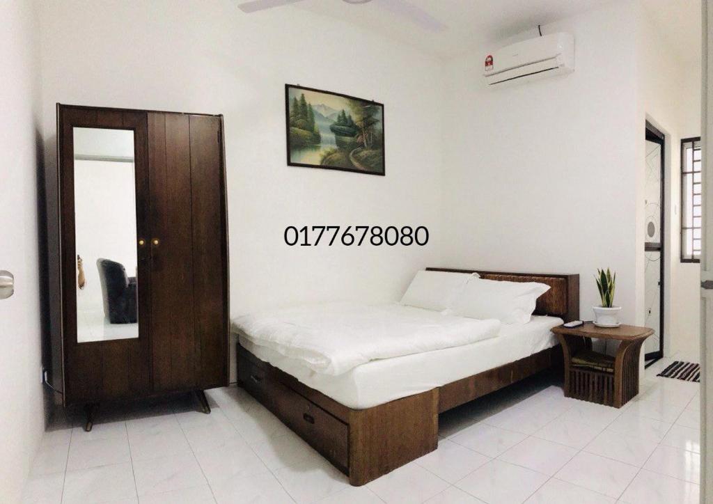 ein Schlafzimmer mit einem Bett und einem Spiegel in einem Zimmer in der Unterkunft Alyn Home Batu Pahat II Wifi Coway in Kampong Mohamad Noor