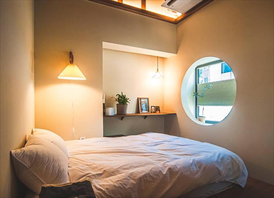 a bedroom with a bed and a round mirror at Jongno Haru in Seoul