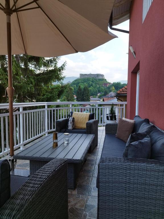 une terrasse avec une table, des chaises et un parasol dans l'établissement Vila Lana, à Jajce
