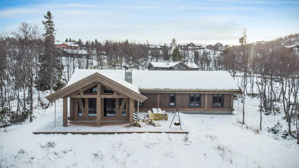 Cabaña de madera con nieve en el suelo en NEW LUXUARY Cabin with perfect location on Geilo. en Flatåker