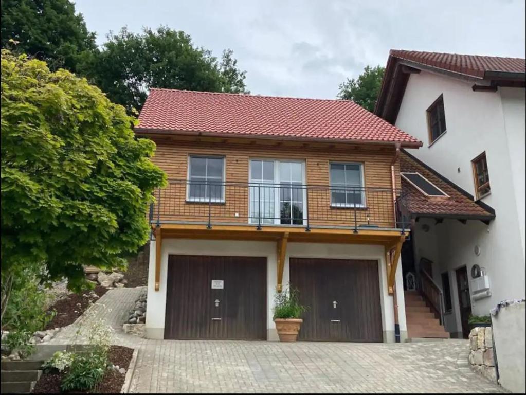 a house with two garage doors and a driveway at Ferienwohnung Verschnuufeckli in Wehr