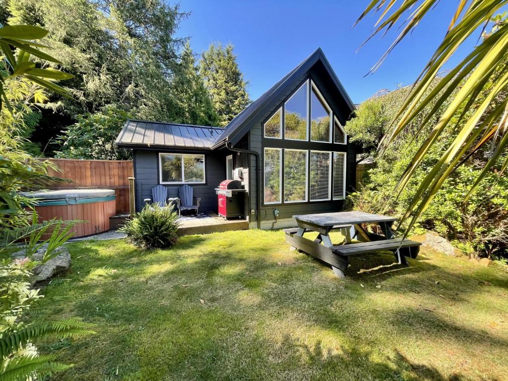 a tiny house with a picnic table in the yard at Beautiful Oceanfront Cabin With Hot Tub! - Gone With The Wind in Ucluelet