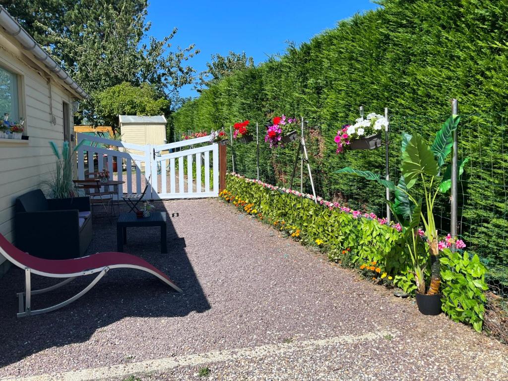 a garden with a bench and a fence with flowers at LES FLORALIES in Froberville