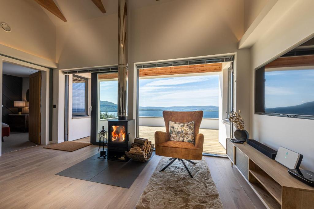 a living room with a chair and a fireplace at Tidal Reach Dunhallin in Hallin
