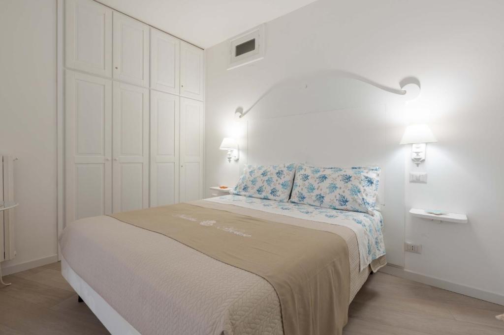 biała sypialnia z łóżkiem z dwoma światłami w obiekcie Nautilus House w mieście Positano