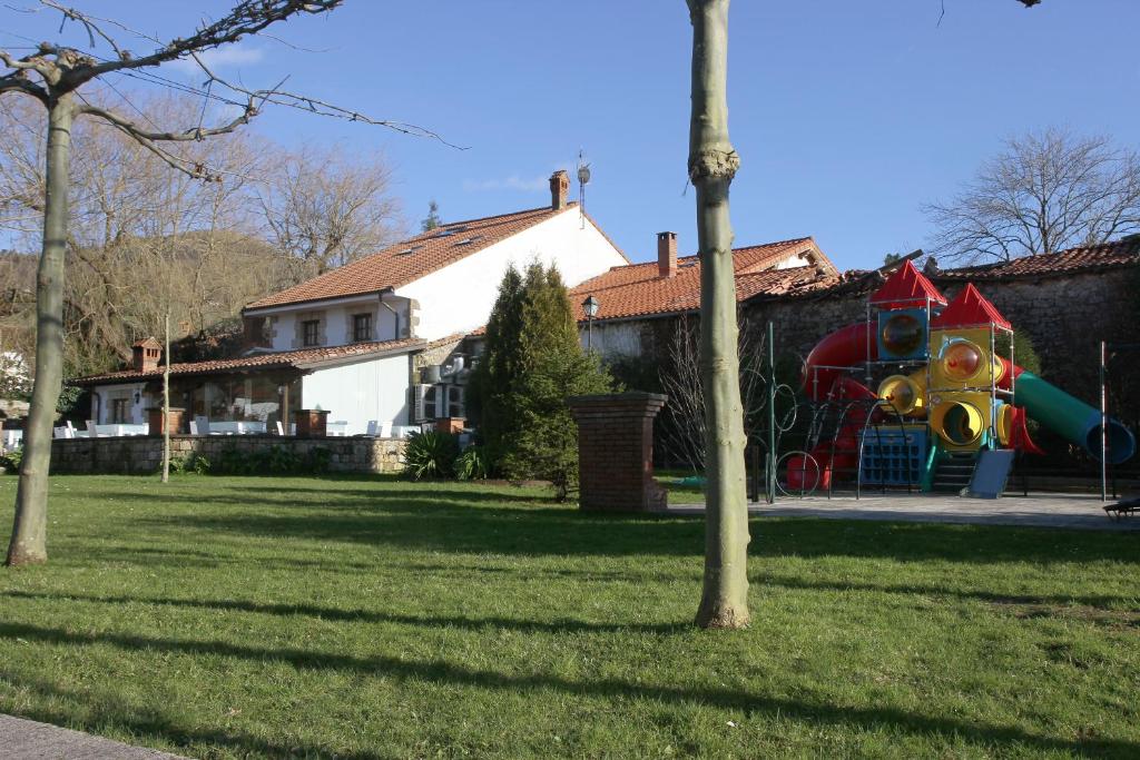 un parque infantil en un patio junto a una casa en Hosteria Hijuelas en Esles