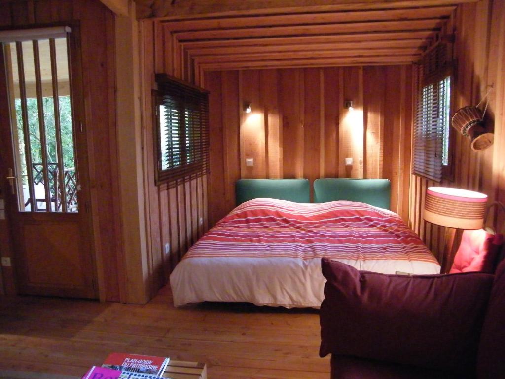 a bedroom with a bed in a room with wooden walls at Particulier in Bordeaux