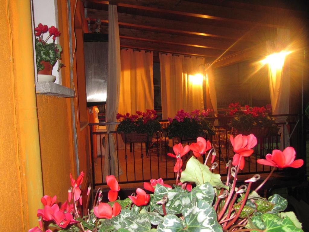 una mesa con flores rojas en el balcón en Montagne Rocciose, en Frascineto
