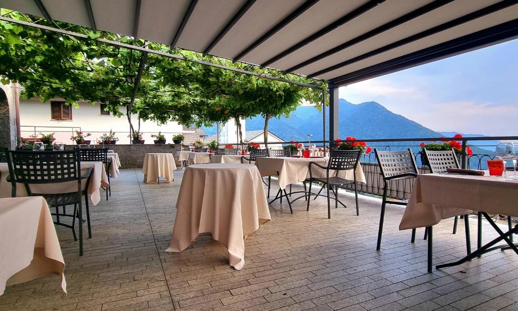 un ristorante con tavoli e sedie con vista sull'oceano di Ristorante Bellavista con Locanda a Veleso