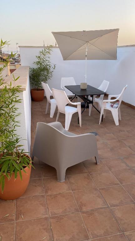 een patio met een tafel en stoelen en een parasol bij Private terrace & Free Parking in Málaga