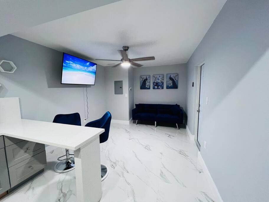 een woonkamer met een plafondventilator en een tafel en stoelen bij Blue Eyes in Miami