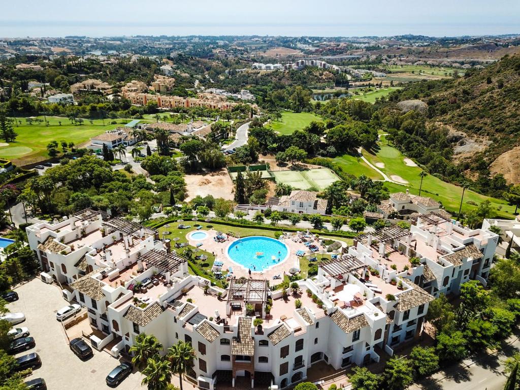 - une vue aérienne sur un complexe avec une piscine dans l'établissement LOS ARQUEROS GOLF APARTMENTS, à Benahavís
