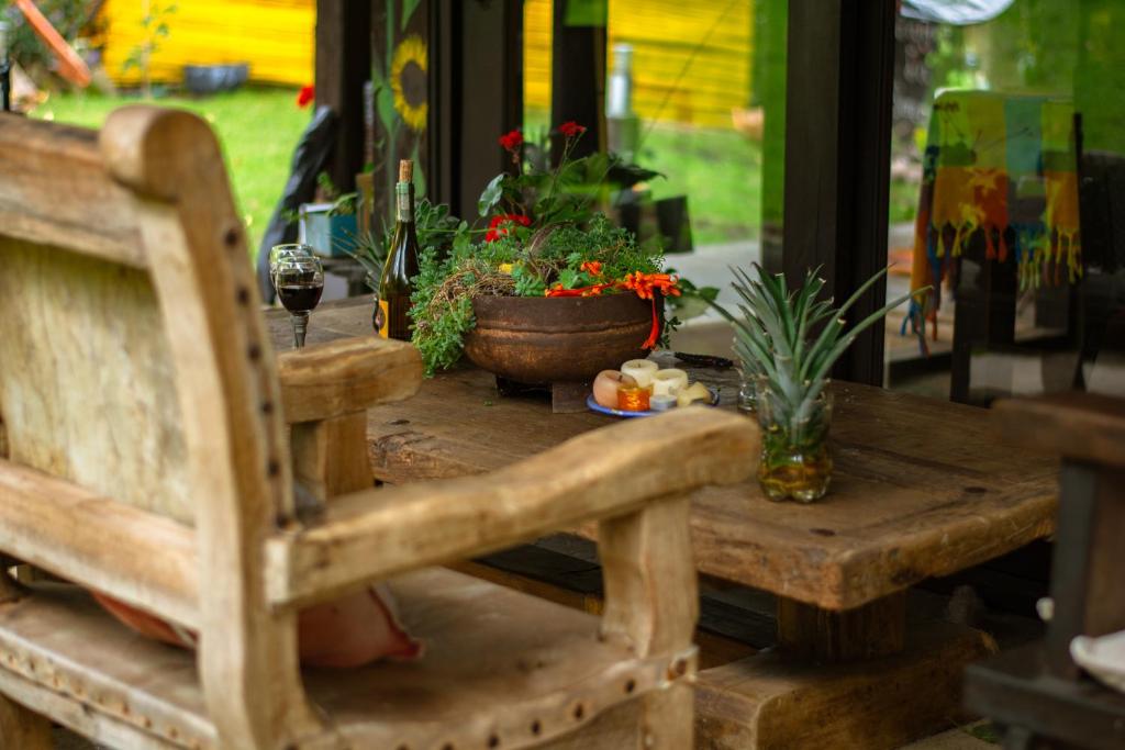 a wooden table with a wooden chair and plants on it at Posada la Serena in Villa de Leyva