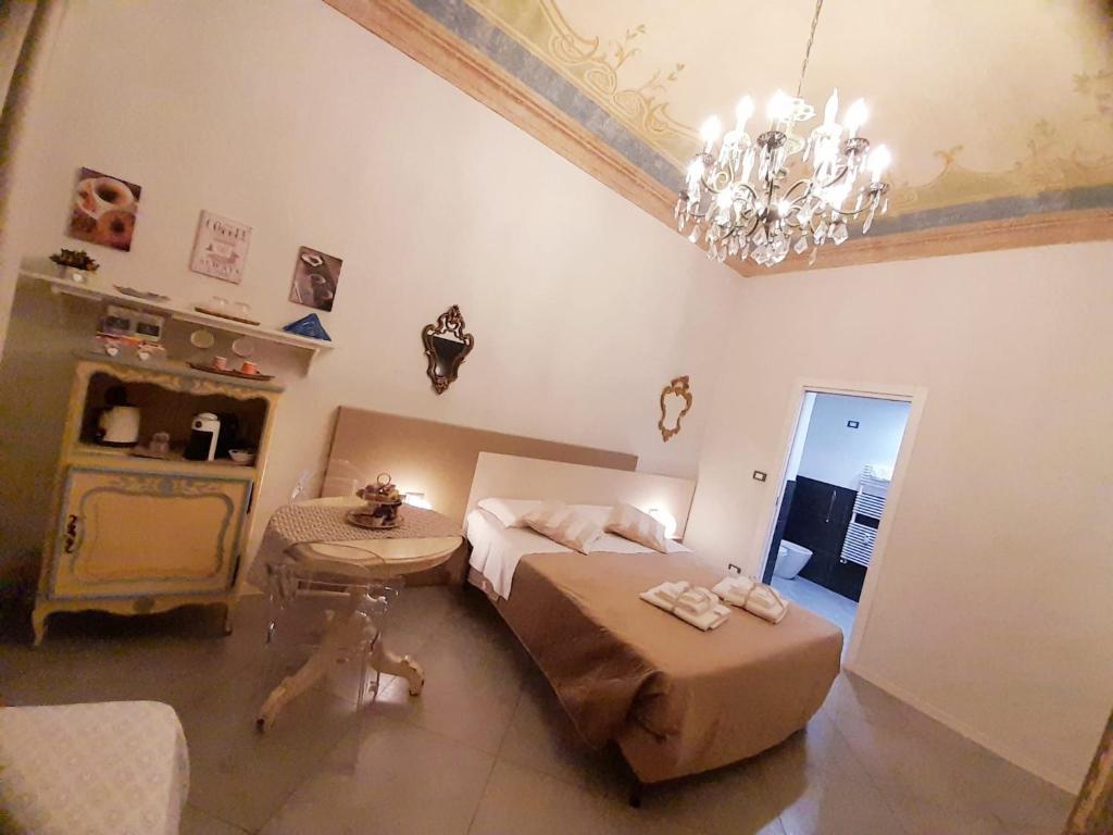 都靈的住宿－Il Sogno Torino Guesthouse，一间卧室配有一张床、一张桌子和一个吊灯。