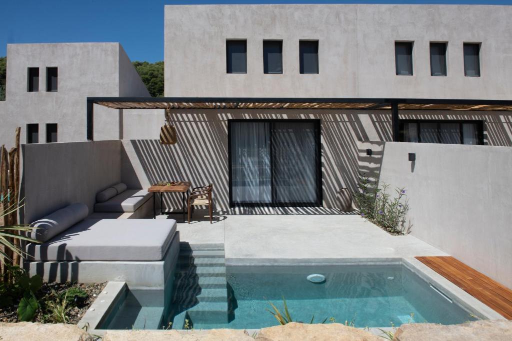 a house with a swimming pool in front of a house at Pure Villas in Ormos Panagias