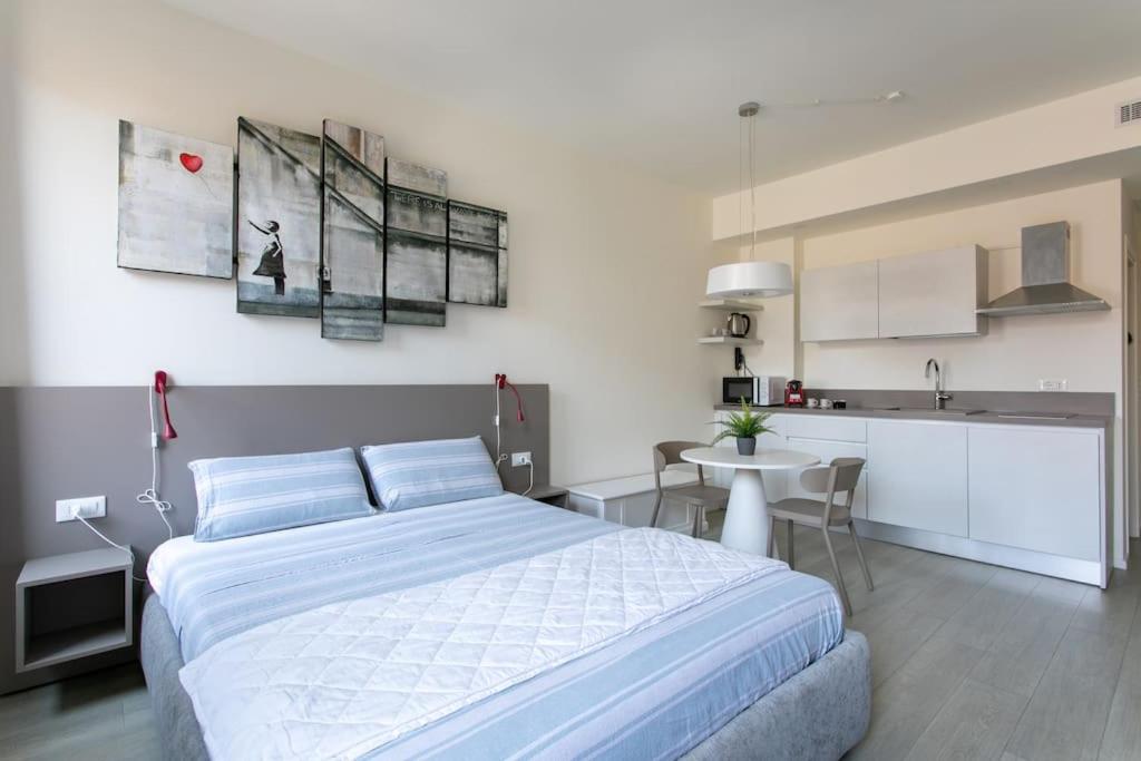 1 dormitorio con 1 cama grande y cocina en Residenza SubitoSanto - Appartamento 5B "Giotto", en Padua