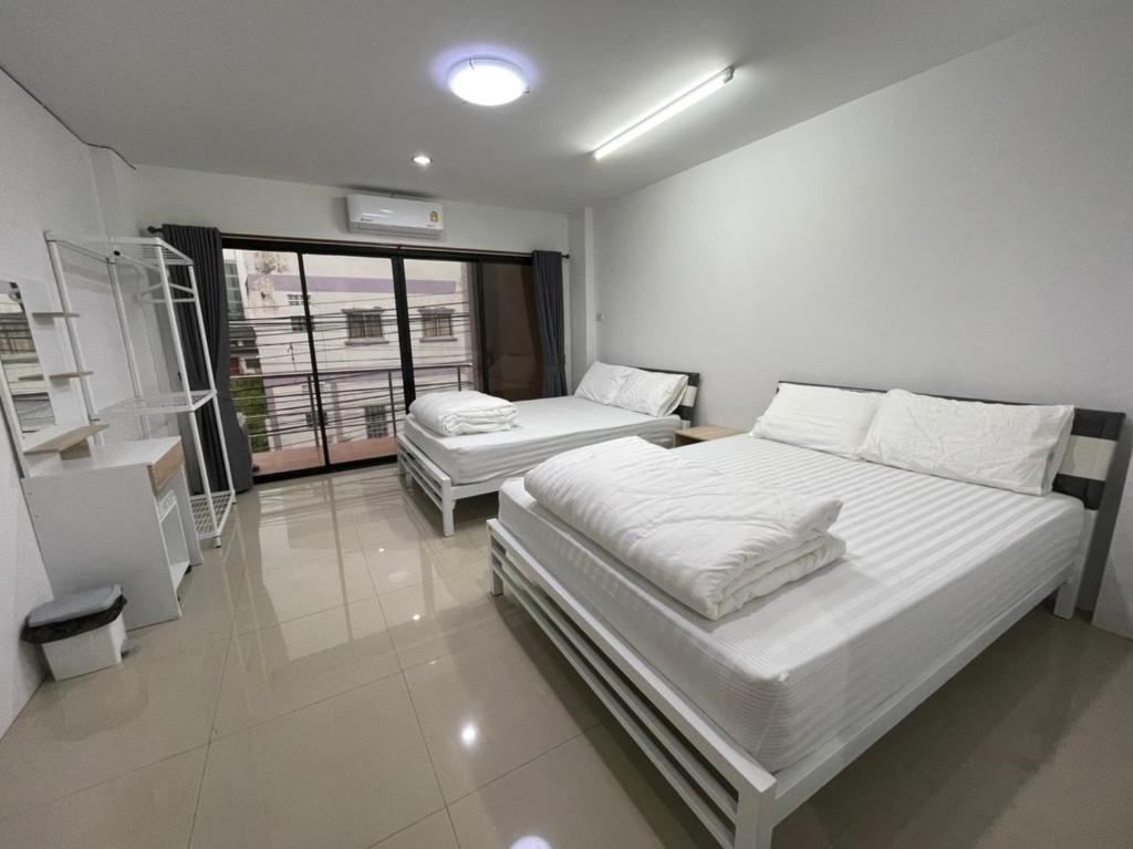 um quarto com 2 camas e uma janela em Khoksametchun Hostel Plus 2 em Hat Yai
