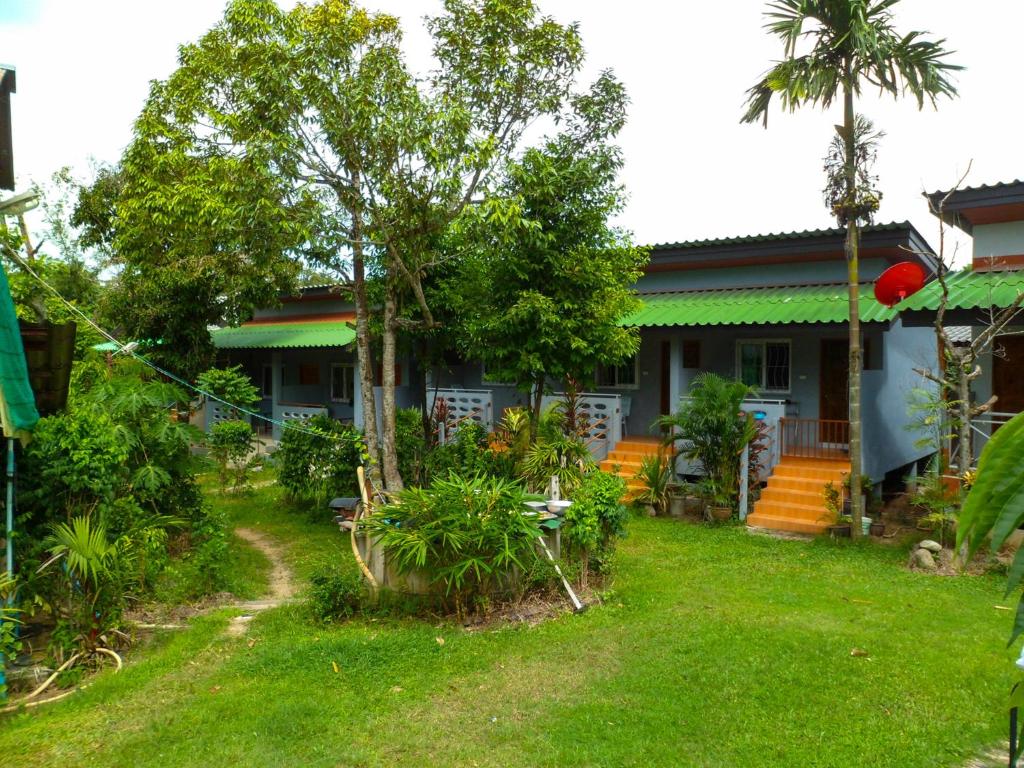 a house with a yard in front of it at Bonus Bungalow in Chalong