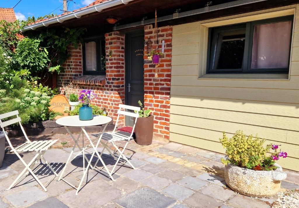 eine Terrasse mit einem Tisch und Stühlen vor einem Haus in der Unterkunft Studio Malow in Arques