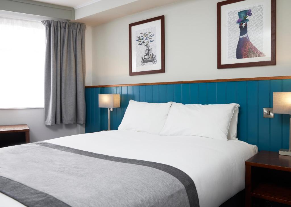 um quarto de hotel com uma cama e uma janela em Highwayman Hotel em Dunstable