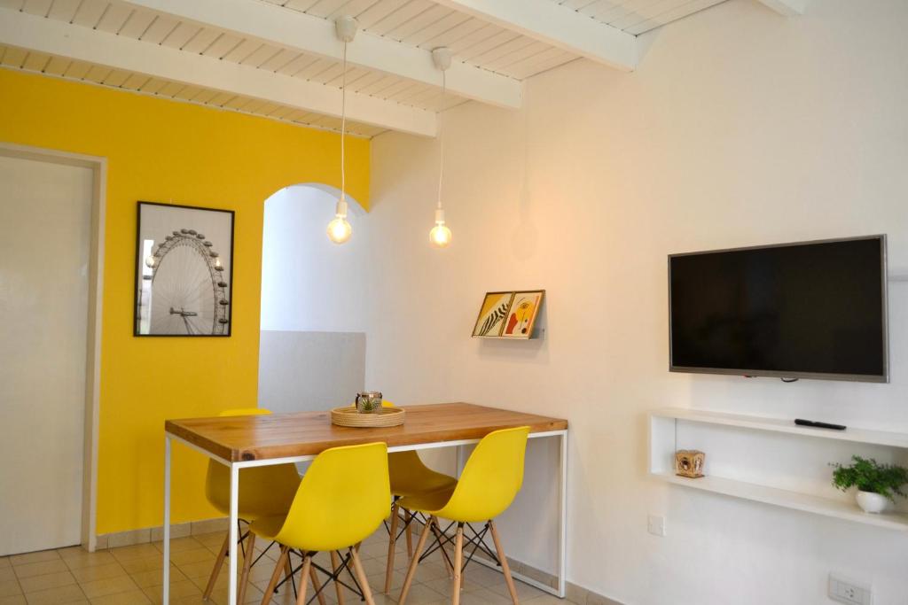 a dining room with a table and yellow chairs at Loft Amarillo in Tandil