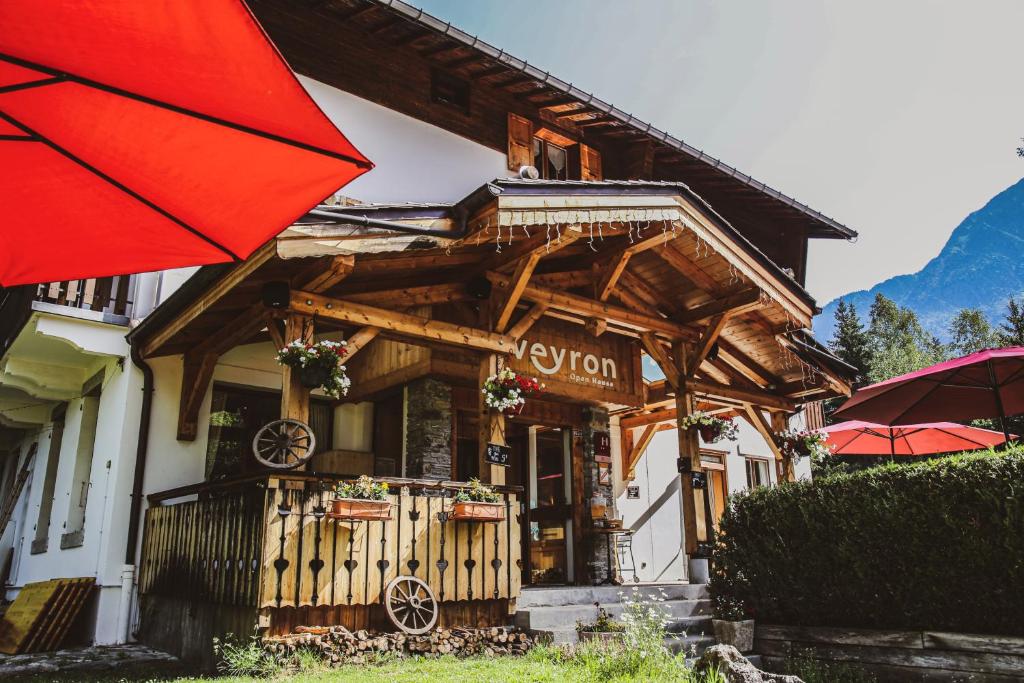 un edificio con un ombrello rosso davanti di L'Arveyron Open House a Chamonix-Mont-Blanc
