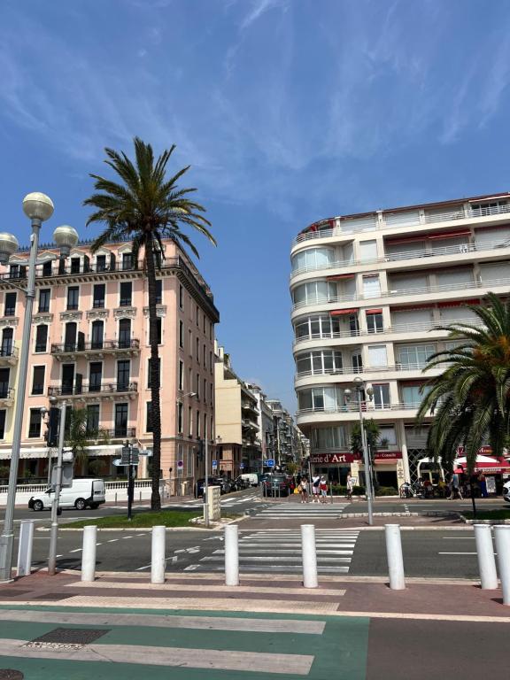 une rue de la ville avec des palmiers et un bâtiment dans l'établissement NICE - Central 100m plage- Negresco - IDEAL COUPLE, à Nice