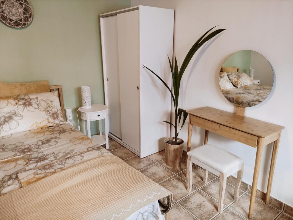 una camera con letto, tavolo e specchio di Cozy apartment in Peania (near Airport) a Paianía