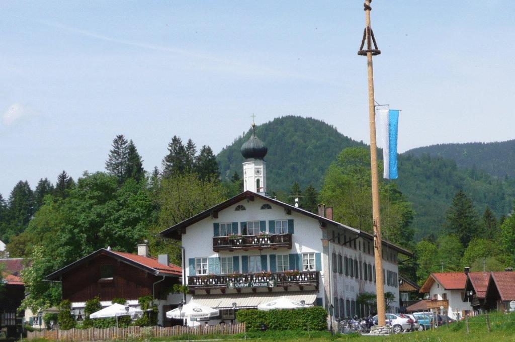 ein Gebäude mit einem Uhrturm darüber in der Unterkunft Gasthof Jachenau in Jachenau