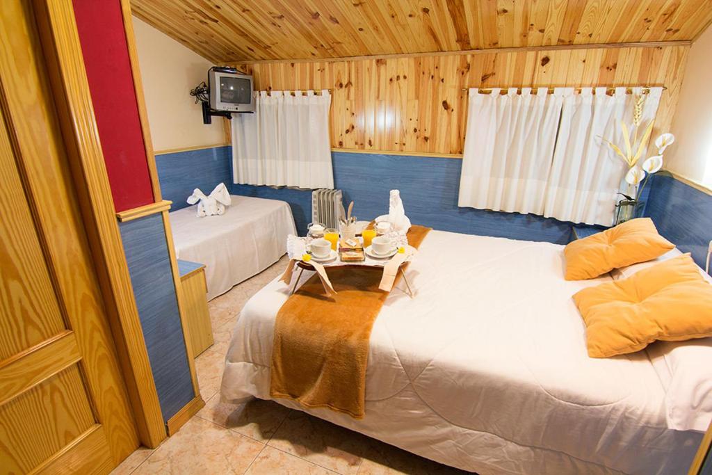 特魯埃爾的住宿－埃爾卡特洛旅館，一间设有两张床和一张桌子的房间
