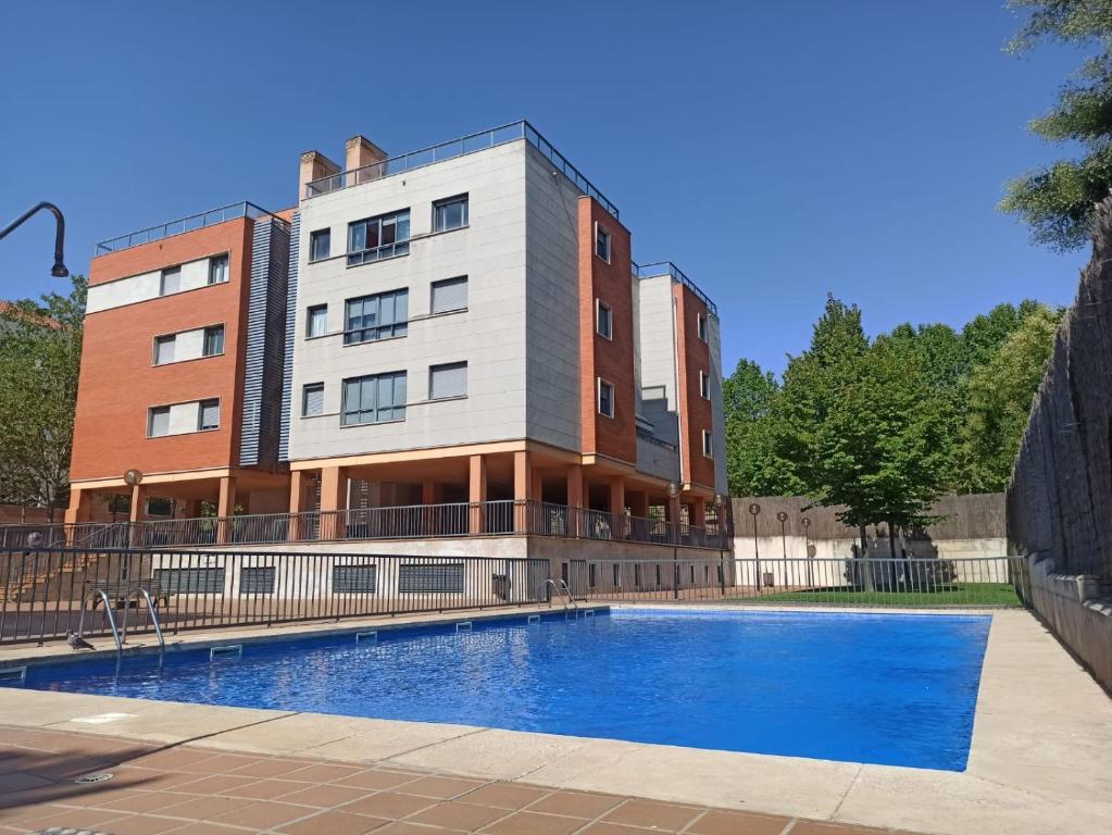 a building with a swimming pool in front of a building at Acogedor y tranquilo in Valladolid