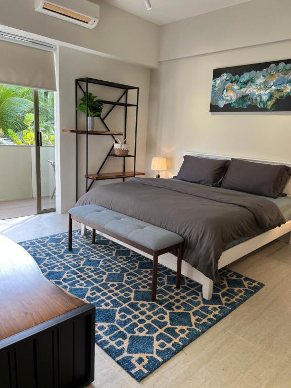 Un dormitorio con una cama grande y una alfombra azul en By The Sea Beachfront Designer Suites Penang - Managed by Art of Tree en Batu Ferringhi