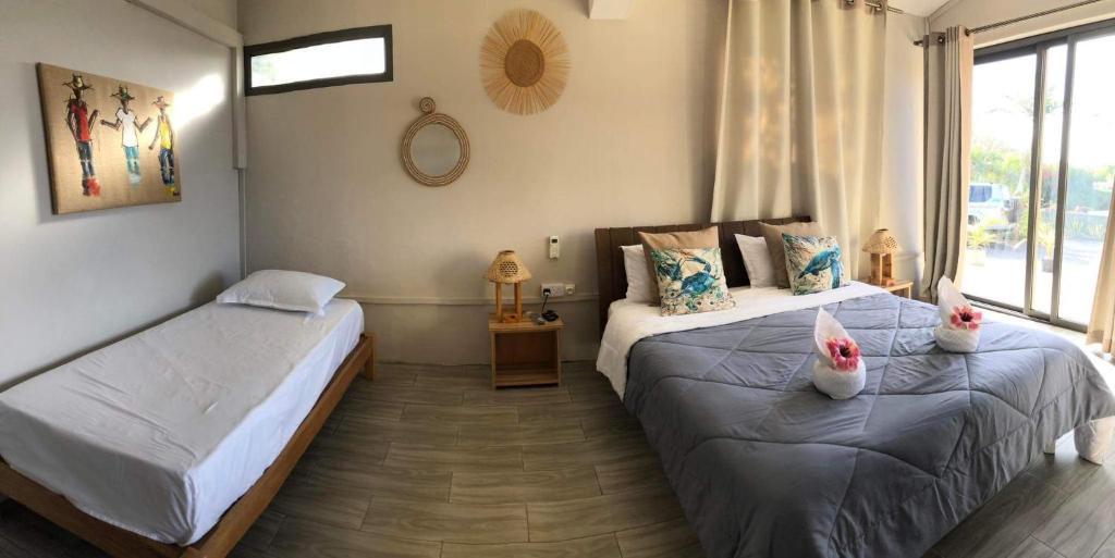 - une chambre avec 2 lits avec des chaussures dans l'établissement Entre Mer et Montagne, à Rodrigues Island