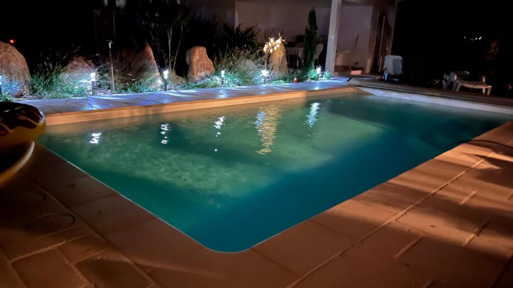 a swimming pool with a fountain at night at Chambre d'hôtes Casa Tib in Prunelli-di-Fiumorbo