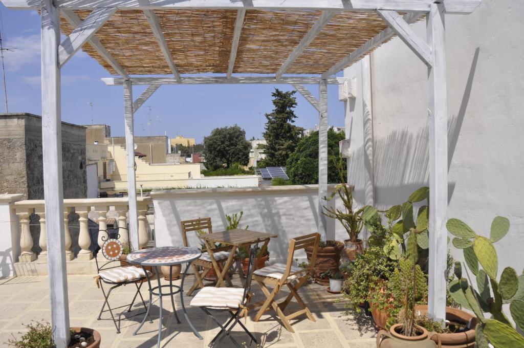 eine Terrasse mit Tischen und Stühlen auf dem Balkon in der Unterkunft Sisters house in Lecce