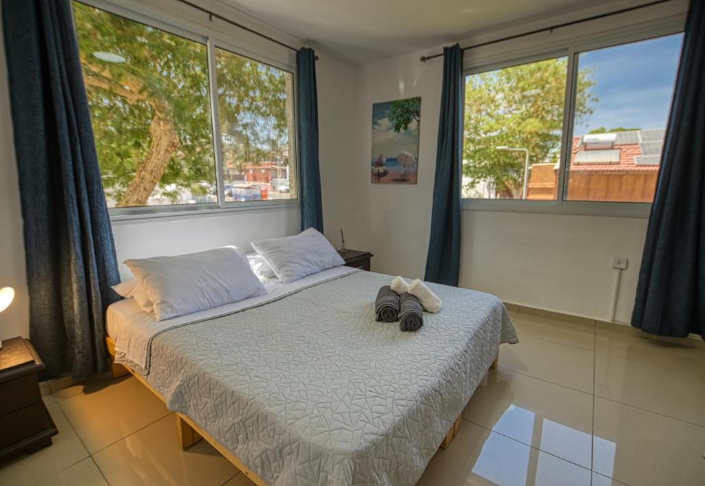 a bedroom with a bed with a pair of shoes on it at The desert Pearl in Eilat