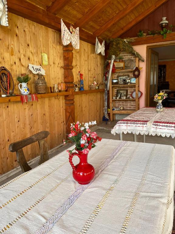 einen Tisch mit einer roten Vase mit Blumen darauf in der Unterkunft Casa Viki 
